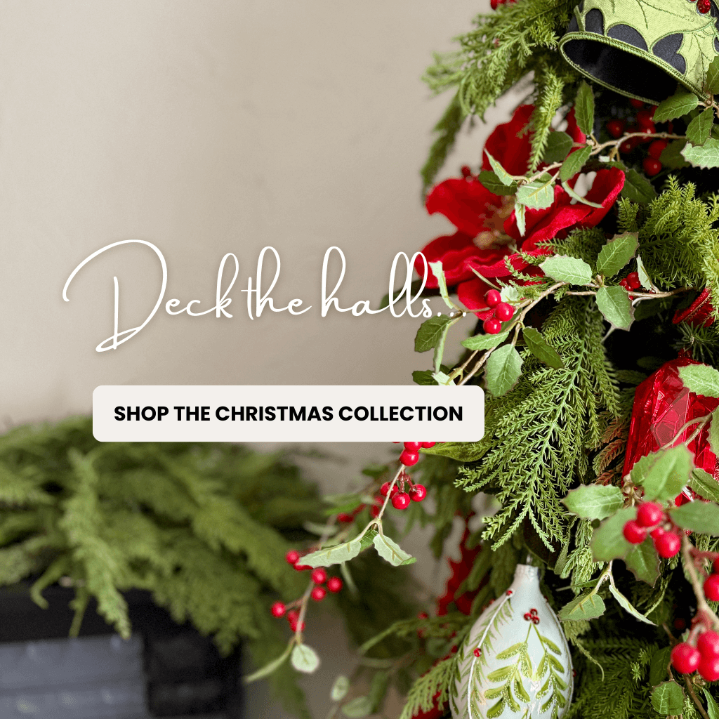 Decorative Christmas wreath with red flowers and green leaves on a neutral background promoting the Christmas Collection