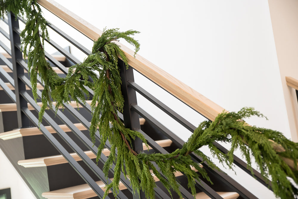 Green garland on a staircase railing indoors