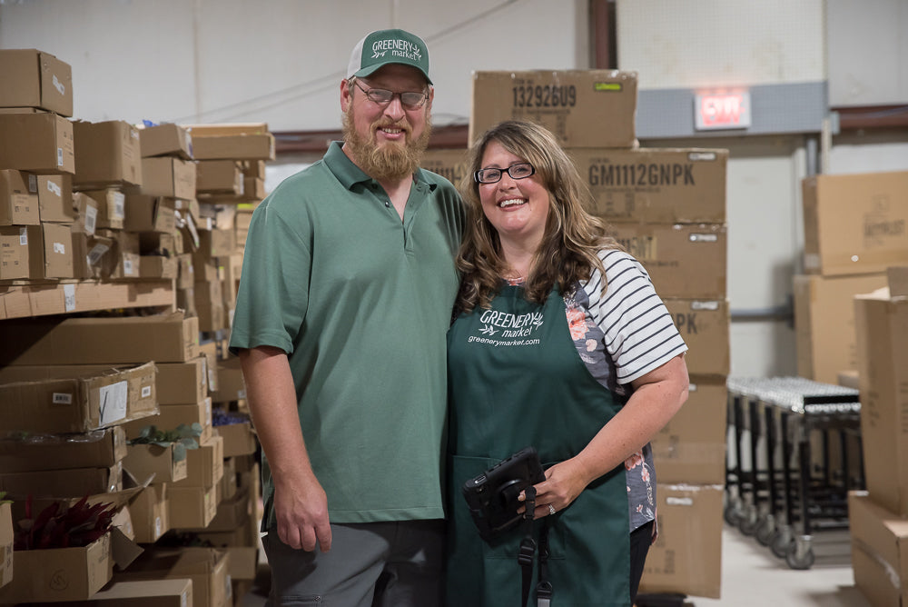 owners bill and alana posing in greenery market warehouse